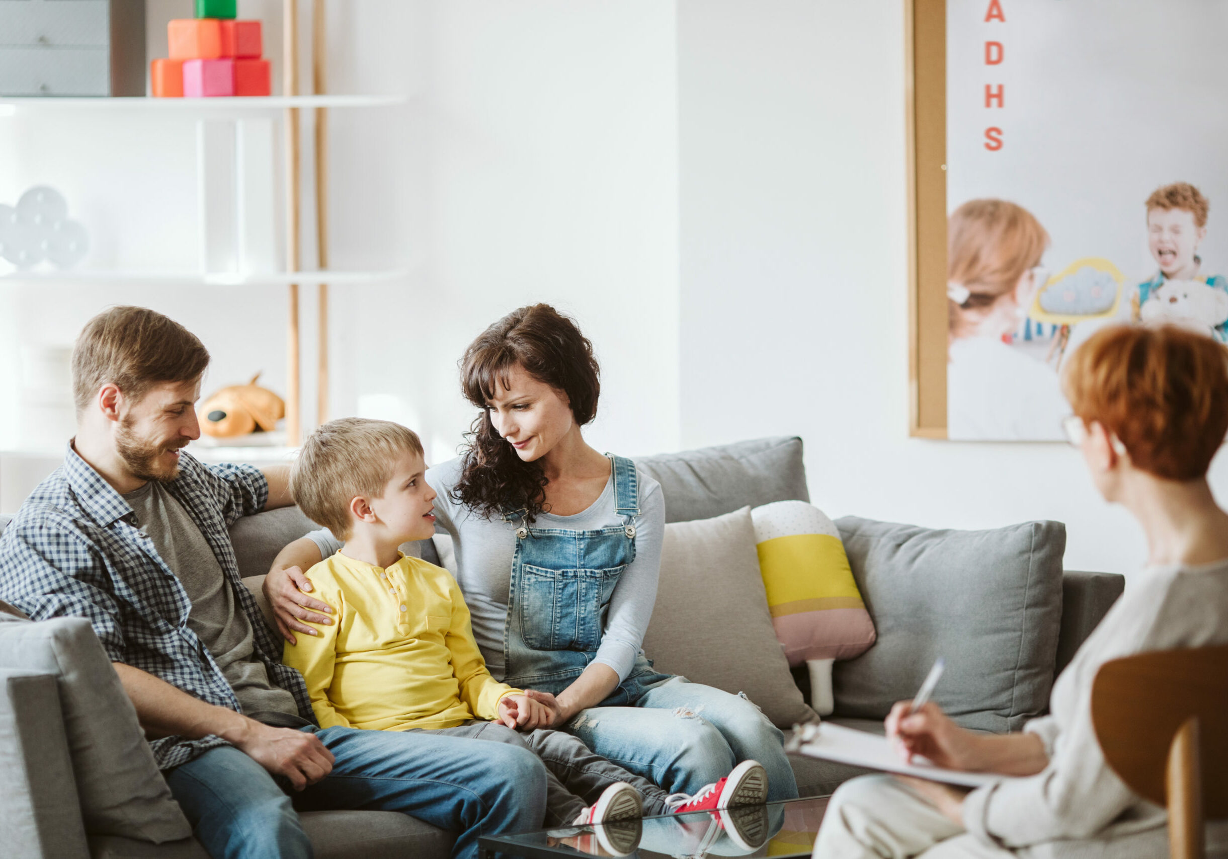 Caring parents and misbehaving boy during therapy session with counselor