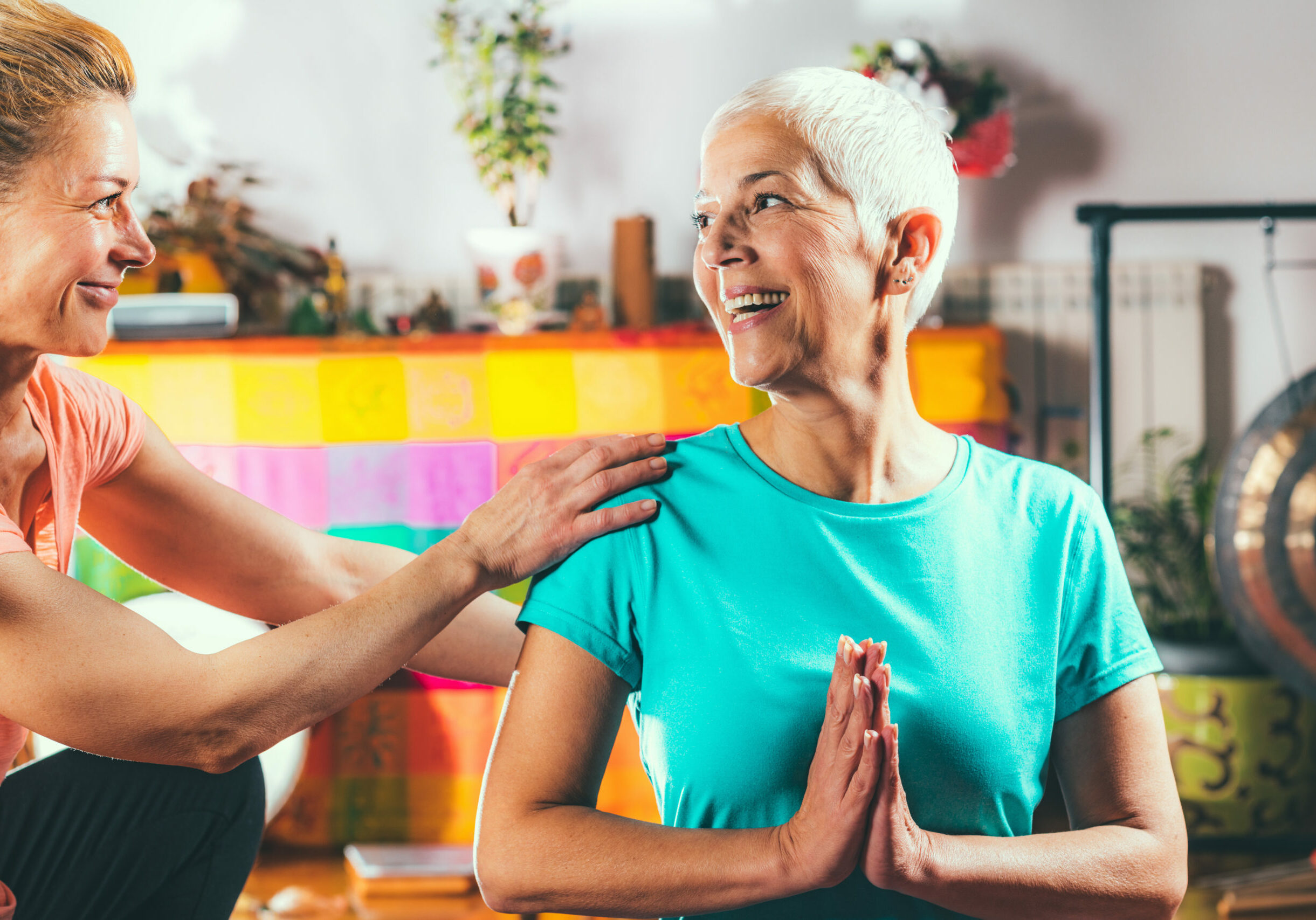 Yoga guru with senior woman, doing yoga